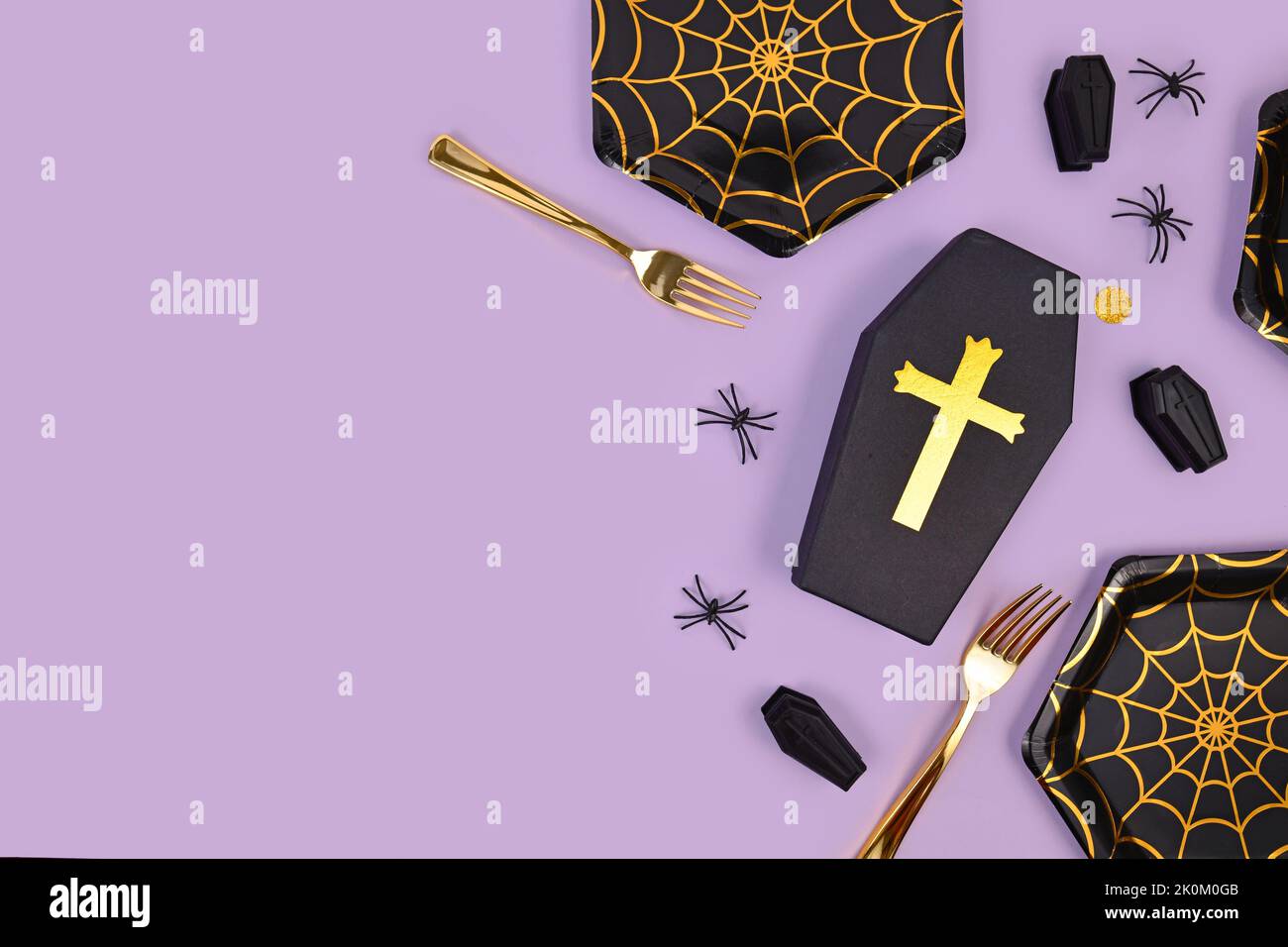 Halloween Party Flat Lay avec des plaques de toile d'araignée, des cercueils, des confettis et des araignées sur fond violet avec espace de copie Banque D'Images