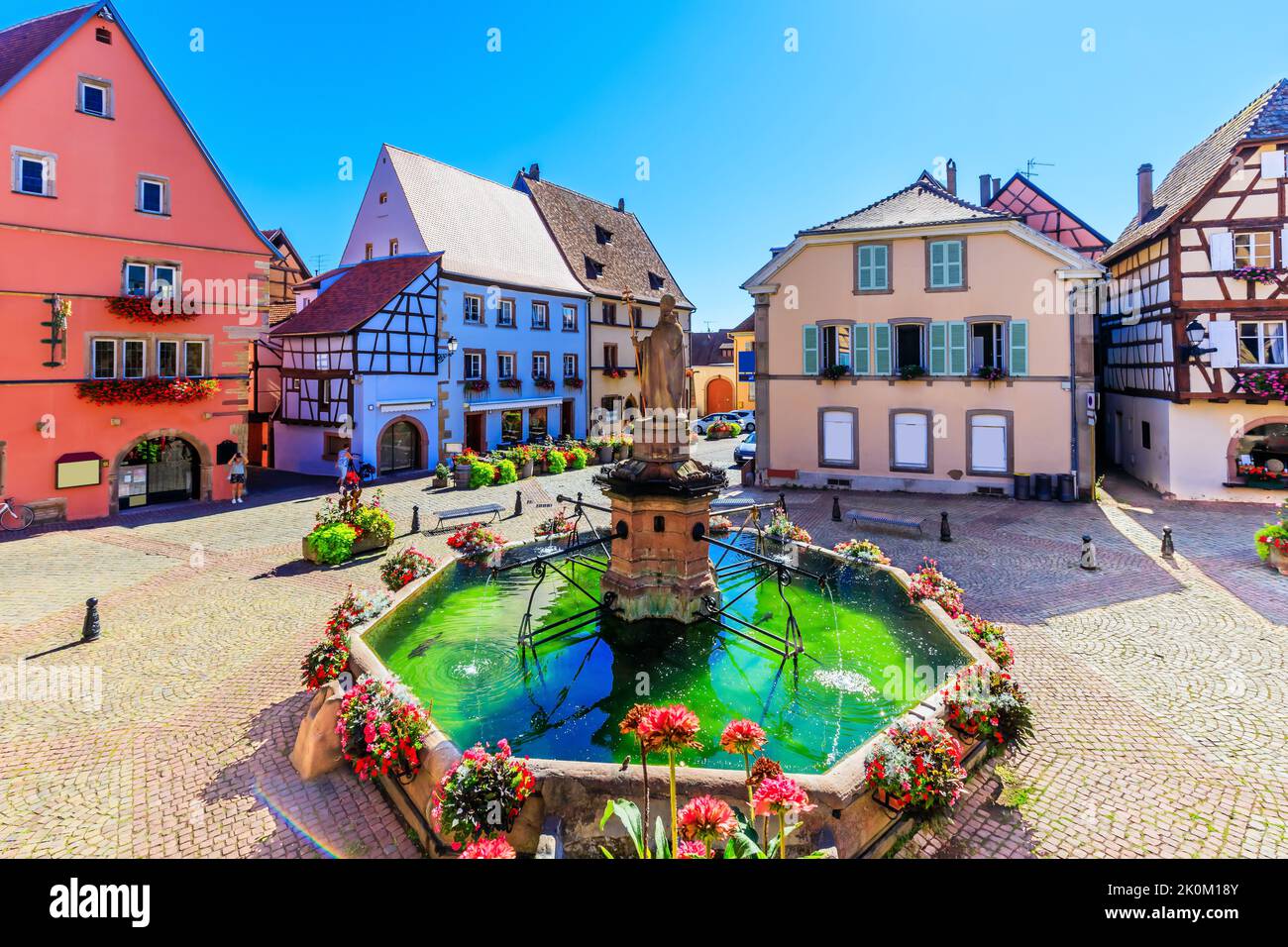 Eguisheim, France. Maisons colorées à colombages sur la place du Château, en Alsace. Banque D'Images