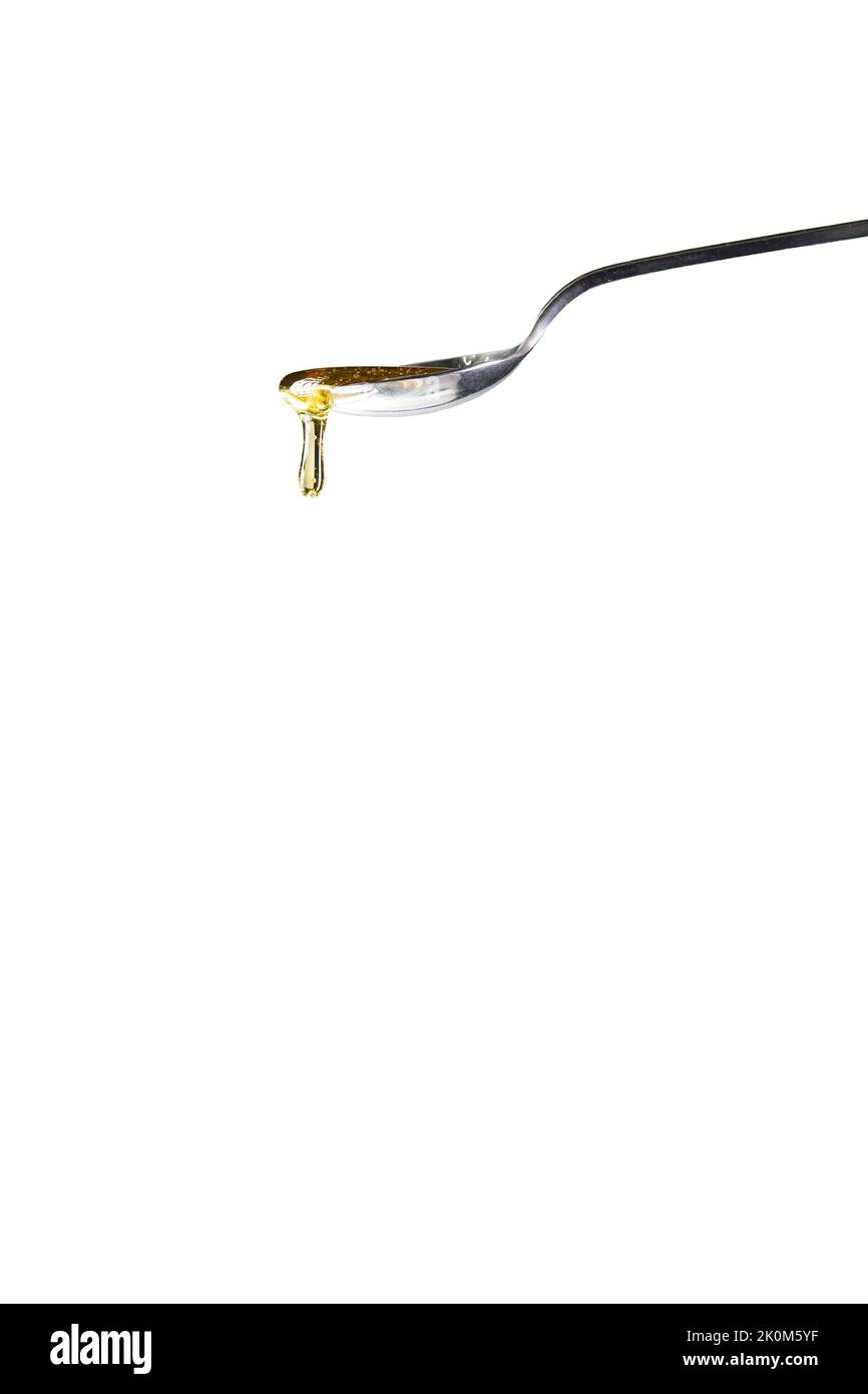 Une cuillère goutte à goutte avec un type de sirop ou de miel. Banque D'Images