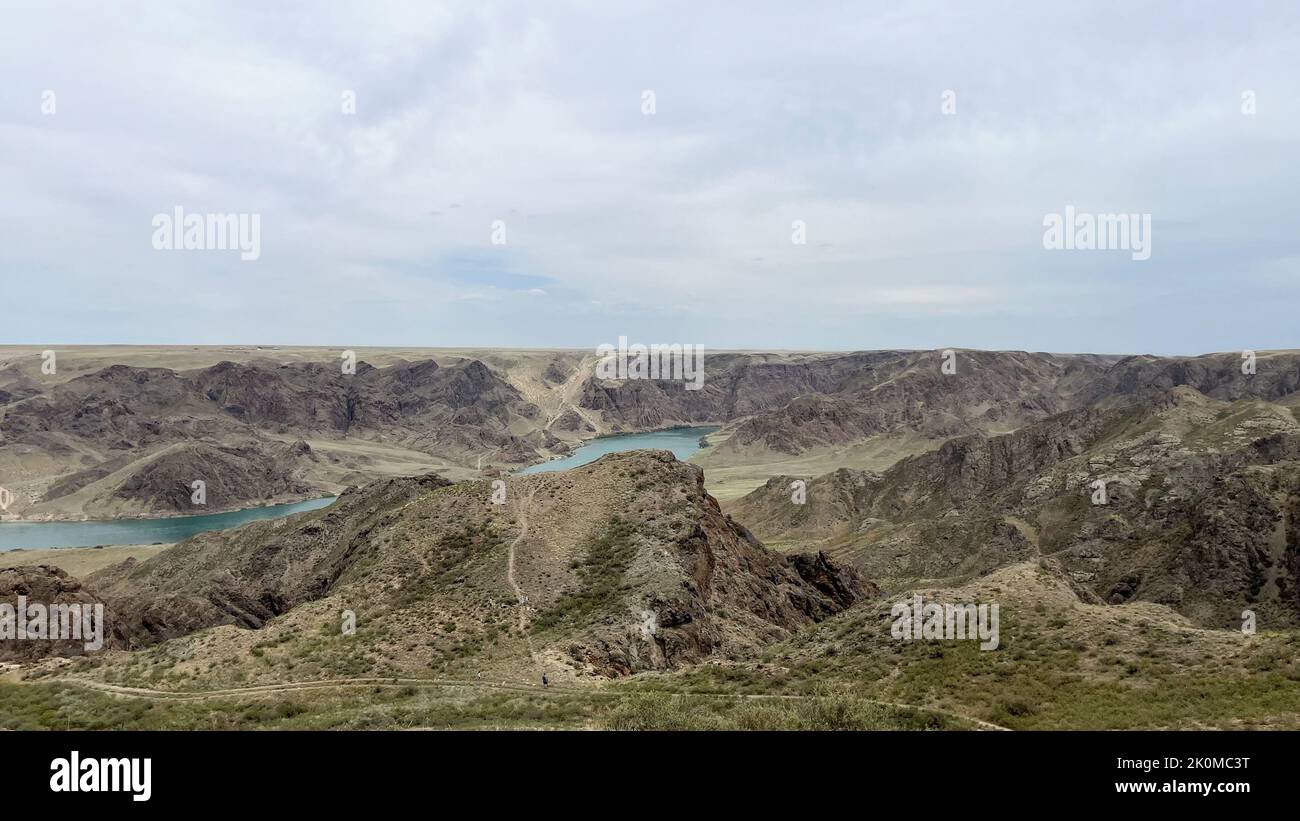 une grande rivière dans la steppe parmi les collines. Banque D'Images
