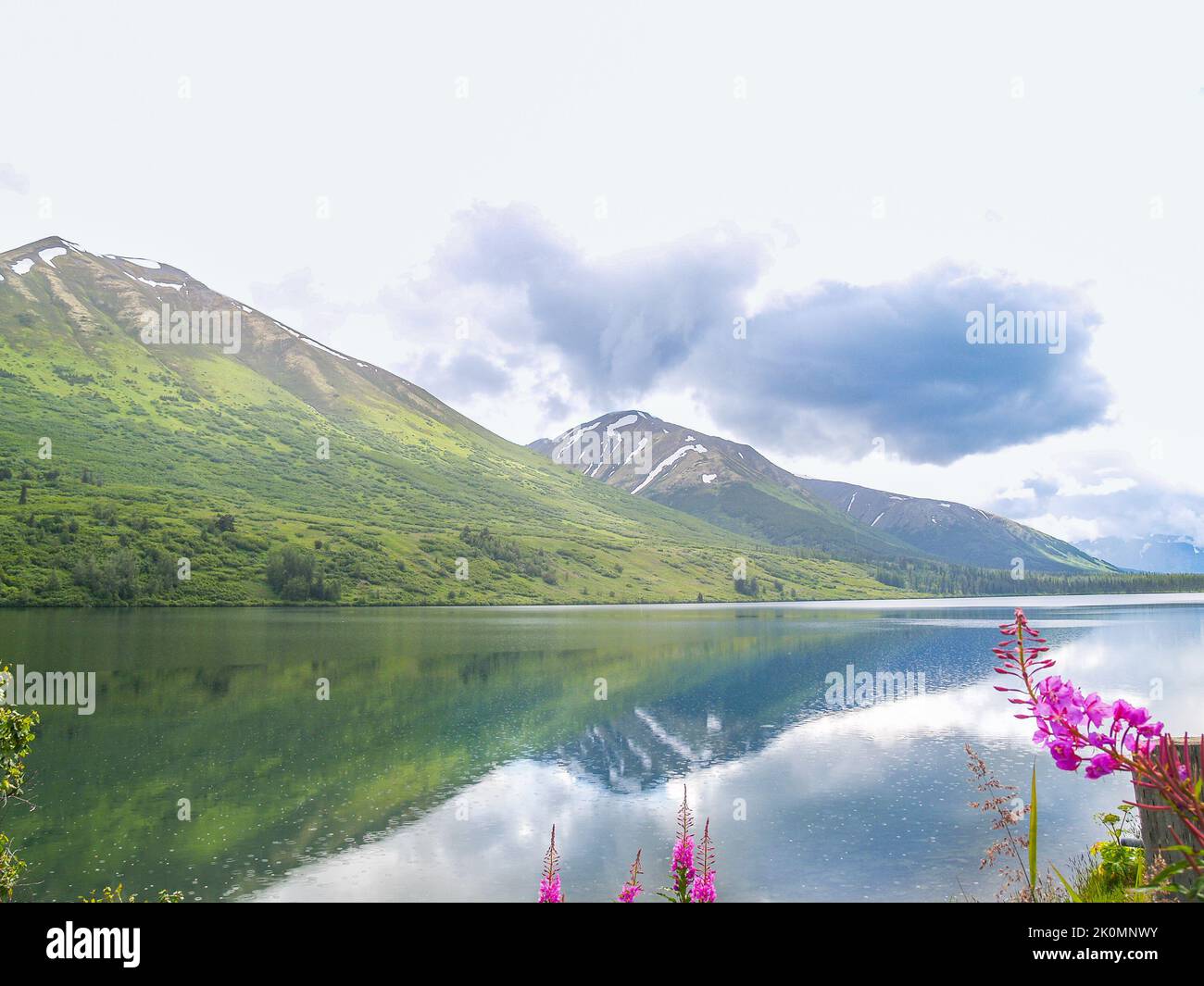 Calme et réflexion dans l'eau calme entouré de collines verdoyantes et de montagnes en Alaska. Banque D'Images