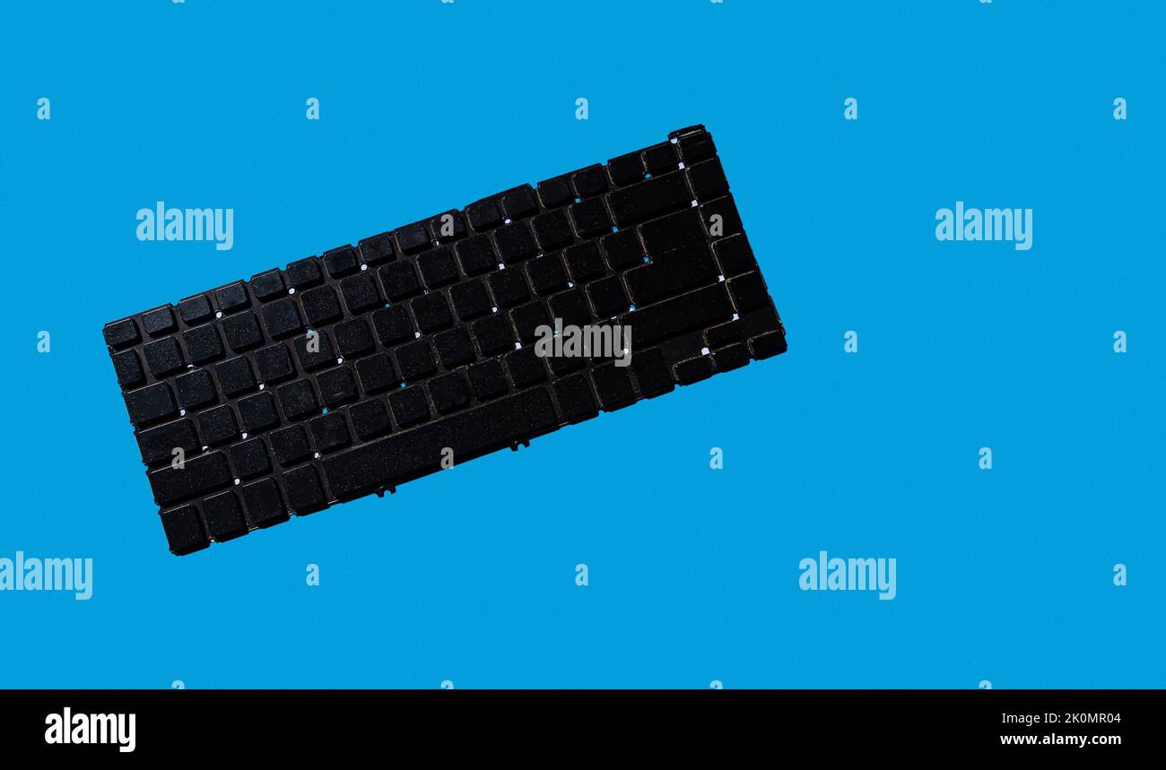 clavier noir de l'ordinateur portable sans lettres ni symboles. style minimaliste. fond bleu uni. technologie moderne. Banque D'Images
