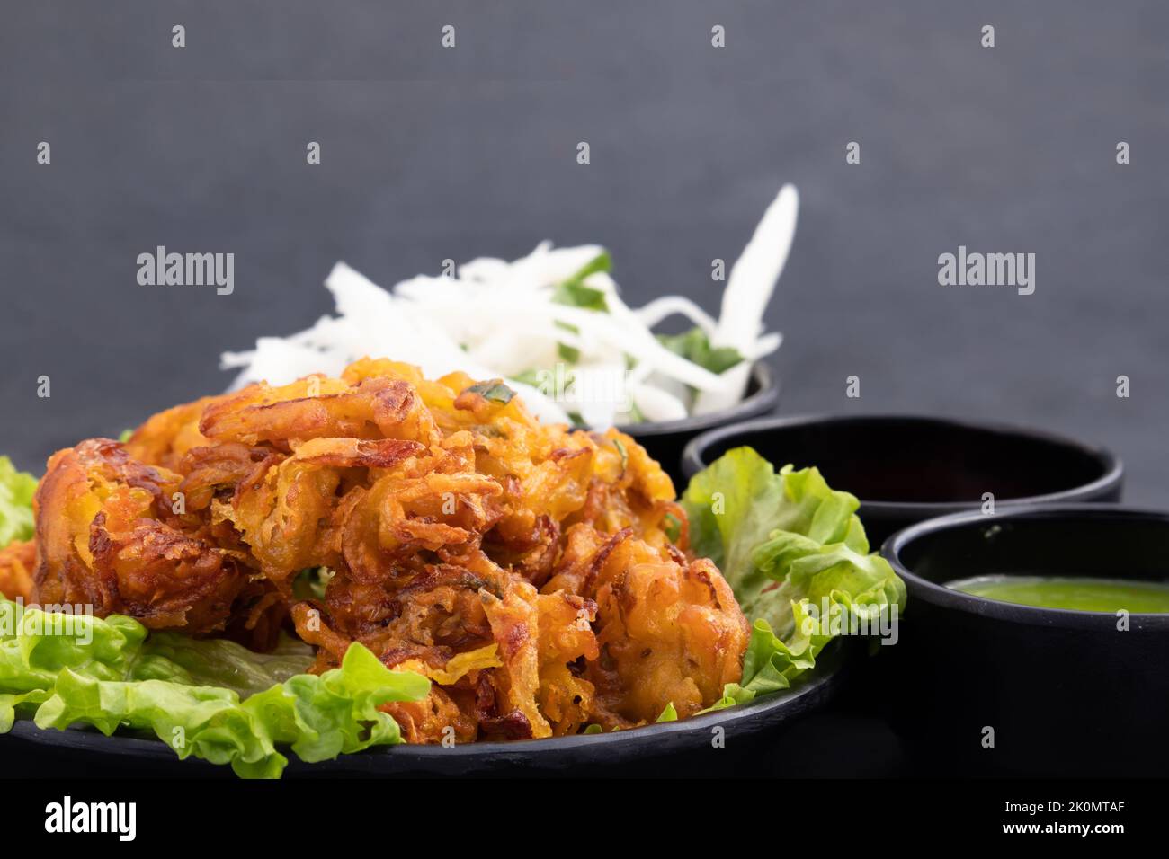 Beignets de thé indien Onion Pakoda également appelé Pyaz Ke Pakore, Kanda Bhajji, Pyaj Bajji, Pyaaz Bhaji ou Pyaaj Pakor est Deep Fried Street fo Banque D'Images