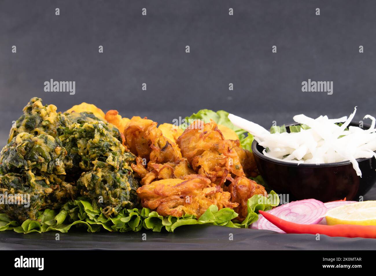 Les beignets indiens d'épinard et d'oignon Pakoda également appelés Pyaz Ke Pakore, Kanda Bhajji, Pyaaz Bajji, Pyaaz Bhaji ou Pyaaj Pakora est Deep Fried Street Banque D'Images