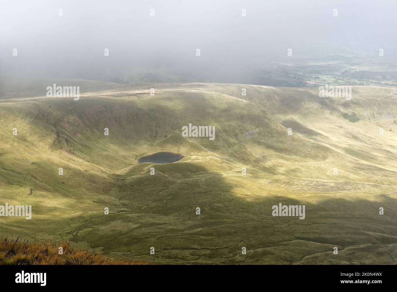 Llyn MCG Llwch lac glaciaire dans le nuage sous Pen y Fan, Brecon Beacons, Powys, pays de Galles, Royaume-Uni Banque D'Images