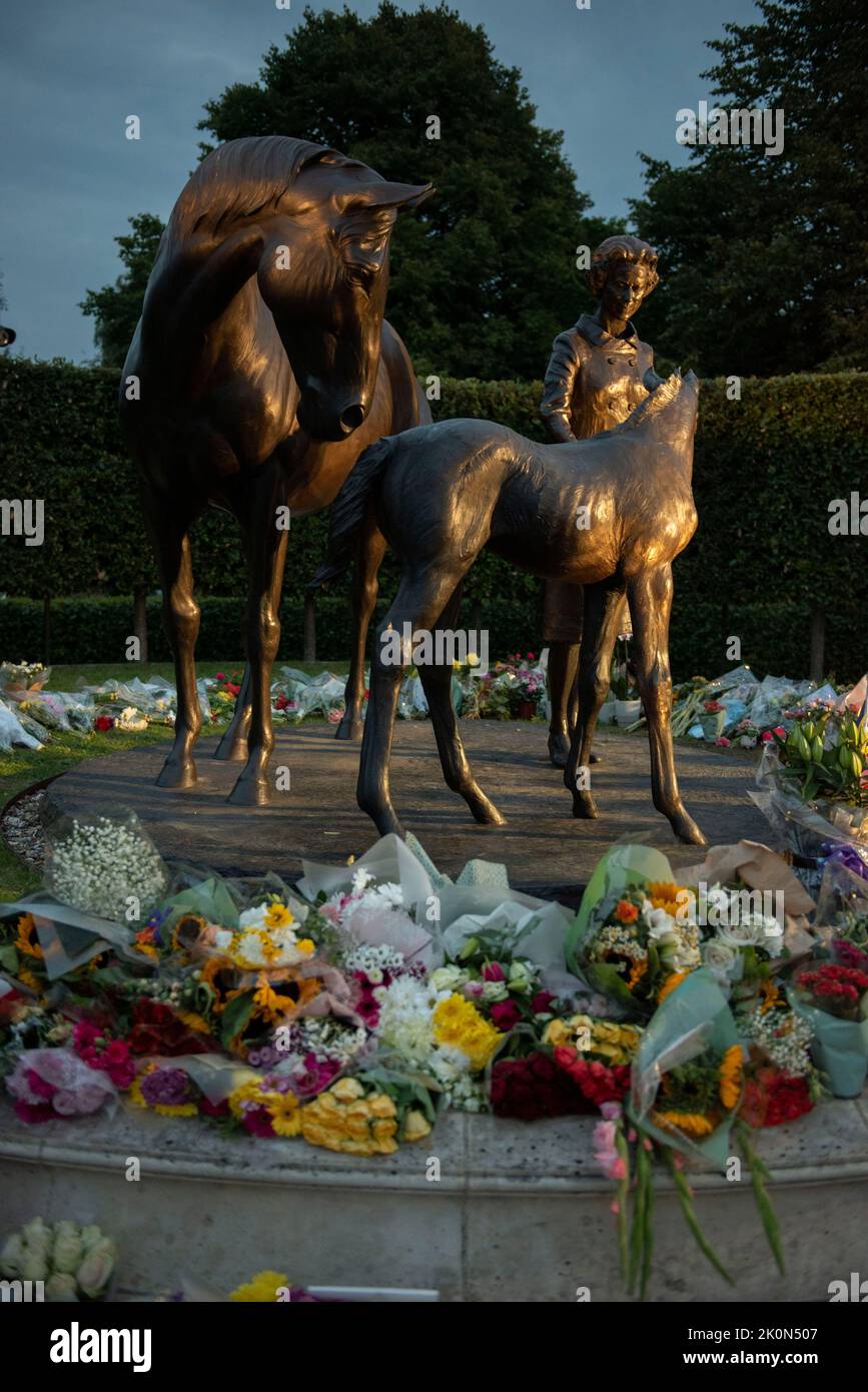 Newmarket, Suffolk, Royaume-Uni. 12th septembre 2022. La statue de la Reine sur Birdcage Walk Newmarket devient un sanctuaire pendant que les gens paient leurs respects. Obscurité. Banque D'Images