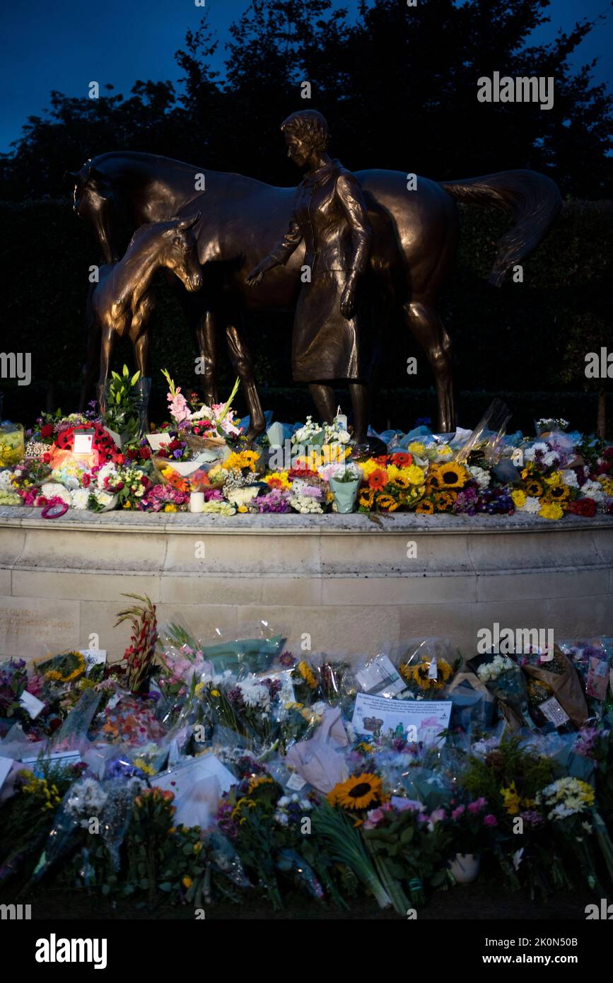Newmarket, Suffolk, Royaume-Uni. 12th septembre 2022. La statue de la Reine sur Birdcage Walk Newmarket devient un sanctuaire pendant que les gens paient leurs respects. Obscurité. Banque D'Images