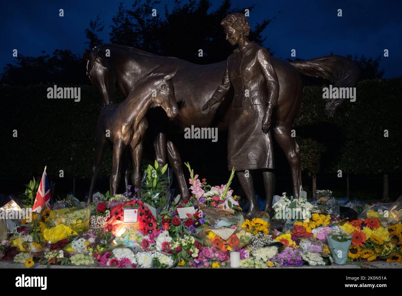 Newmarket, Suffolk, Royaume-Uni. 12th septembre 2022. La statue de la Reine sur Birdcage Walk Newmarket devient un sanctuaire pendant que les gens paient leurs respects. Obscurité. Banque D'Images