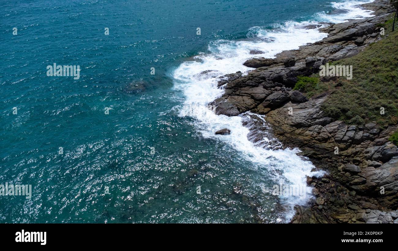Vue aérienne des vagues de mer s'écrasant sur les rochers de la falaise dans l'océan bleu. Vue sur les rochers côtiers de l'océan de Phuket. Point de vue sur le paysage de Laem Phromthep Banque D'Images