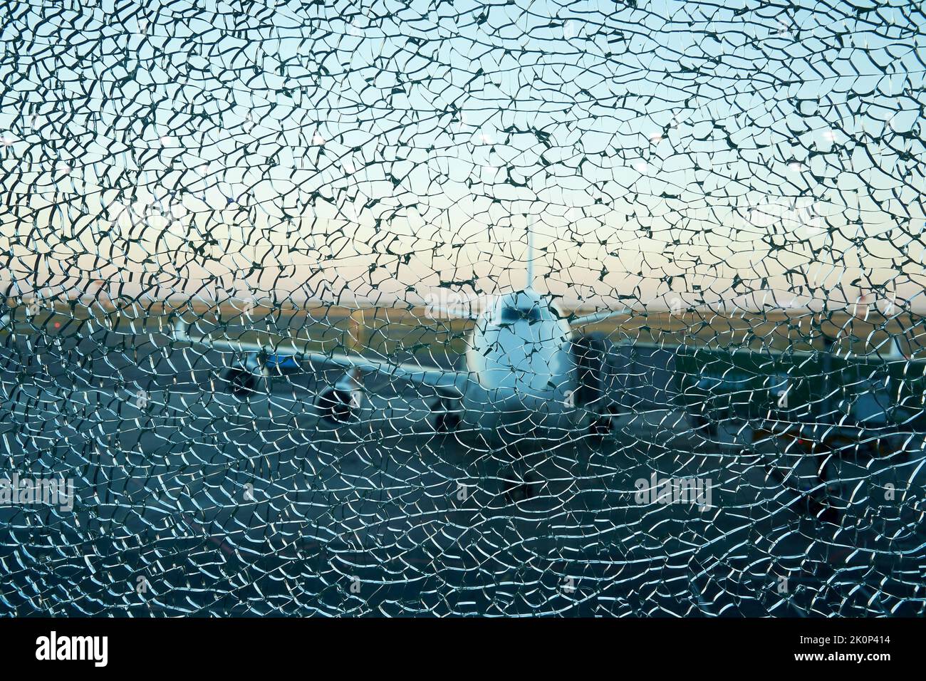 Vue sur la silhouette de l'avion au-dessus de la fenêtre fissurée de l'aéroport. Catastrophe et crash concept Banque D'Images