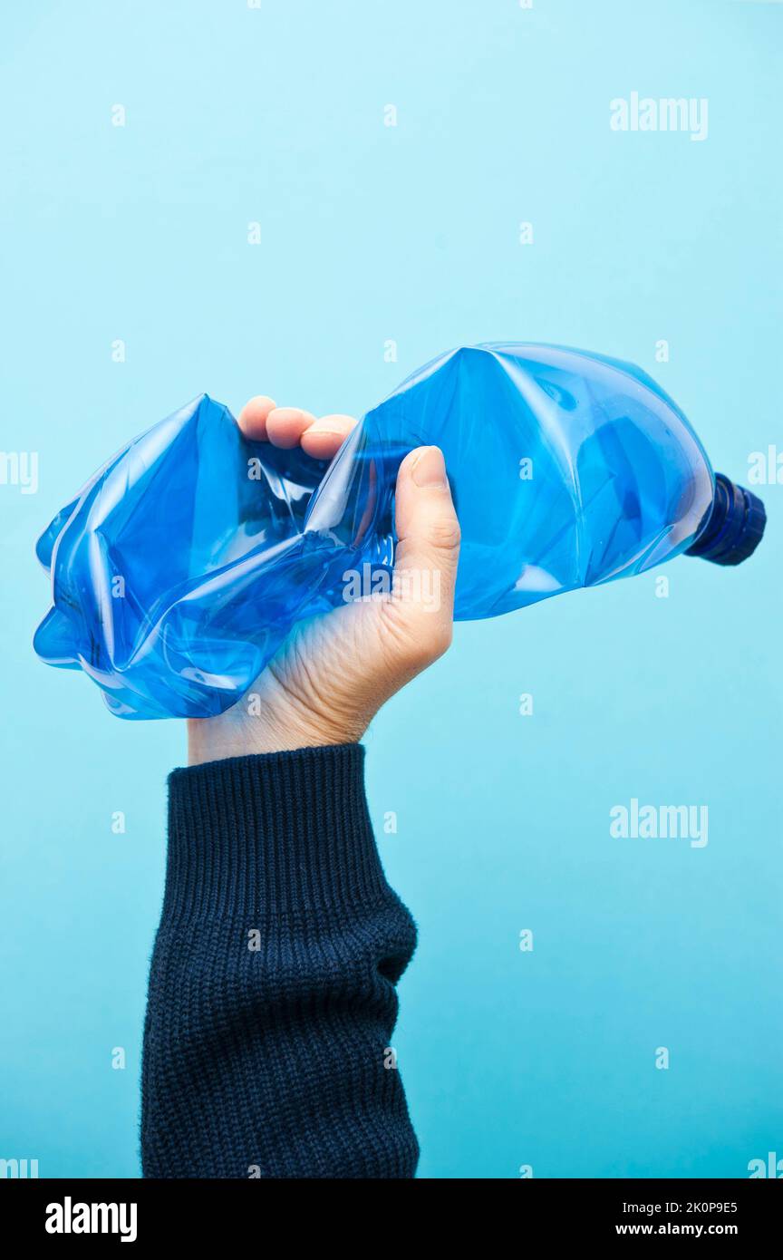 main tenant une bouteille en plastique bleu, concept de recyclage Banque D'Images