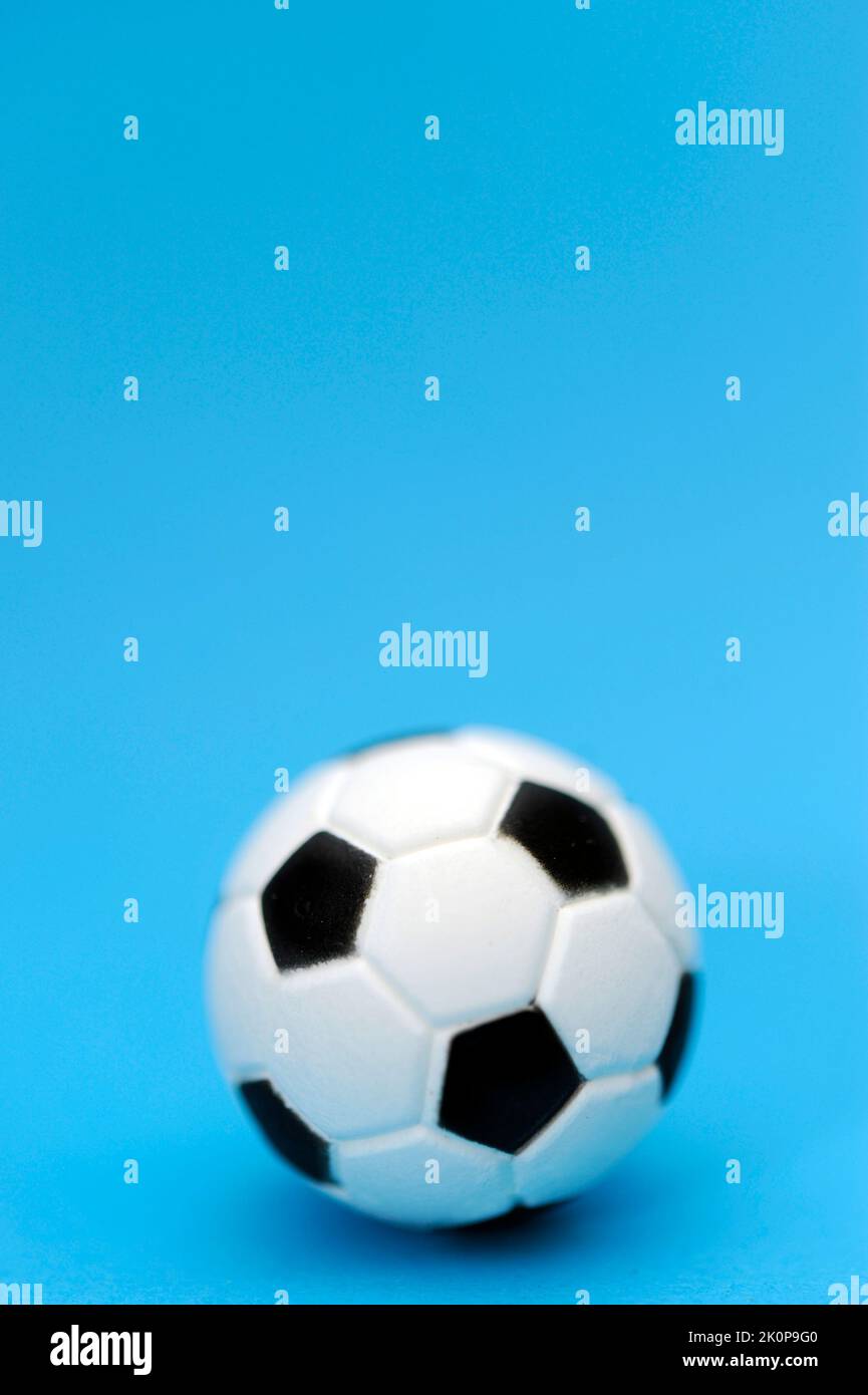 ballon de football miniature sur fond bleu Banque D'Images