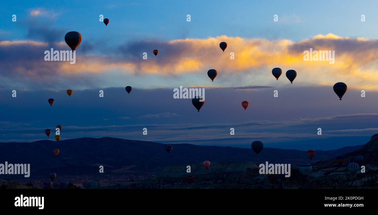 GÖREME/TURQUIE - 27 juin 2022 : des ballons à air chaud survolent le ciel de la cappadoce à l'aube Banque D'Images