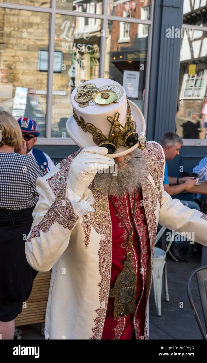 Gentleman dans le costume de Steampunk montrant chapeau blanc avec la décoration des pièces d'horloge. Lincoln 2022 Banque D'Images
