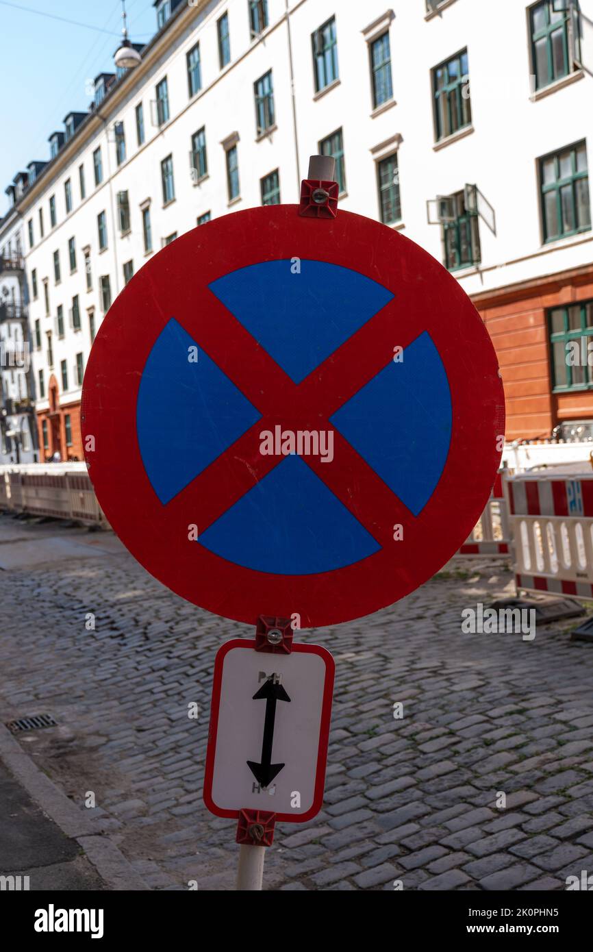 Pas d'arrêt ou de parking sur la rue avec bâtiment blanc et orange en arrière-plan Banque D'Images