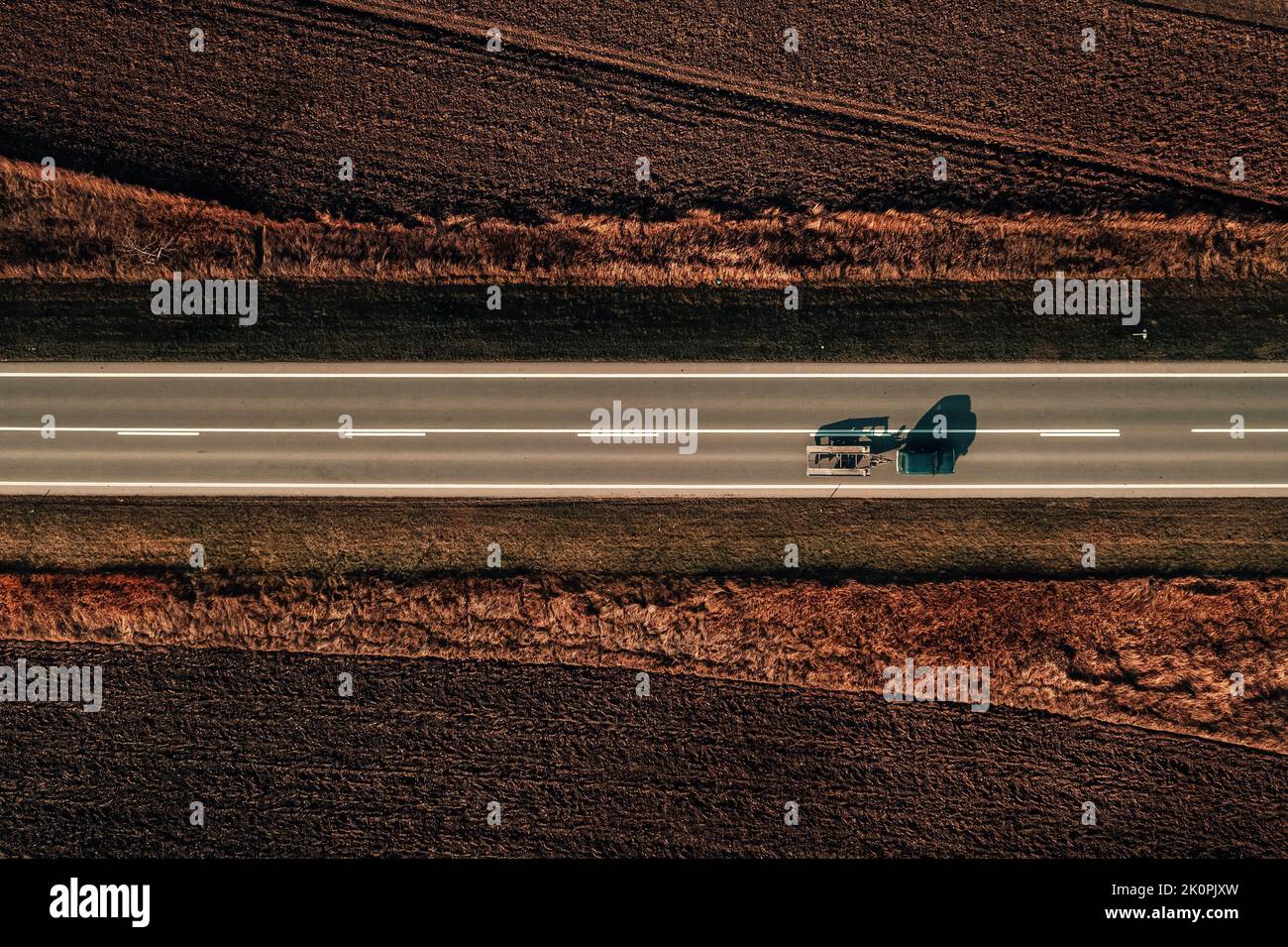 Vue aérienne de la voiture avec remorque de remorquage sur la route à travers la campagne paysage d'automne, photographie de haut en bas de drone Banque D'Images