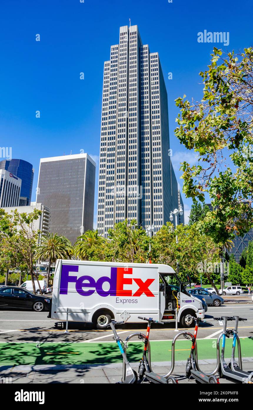 Un minibus de livraison FedEx blanc sur l'Embarcadero à San Francisco, en Californie, devant le four Embarcadero Centre, un grand gratte-ciel. Banque D'Images