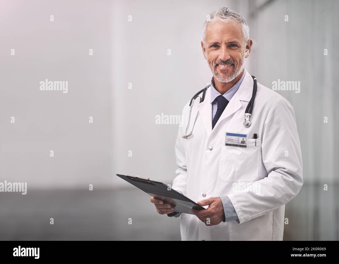 Ici pour vous aider à vous orienter vers une bonne santé à nouveau. Portrait d'un médecin homme mature debout avec un presse-papiers dans un hôpital. Banque D'Images