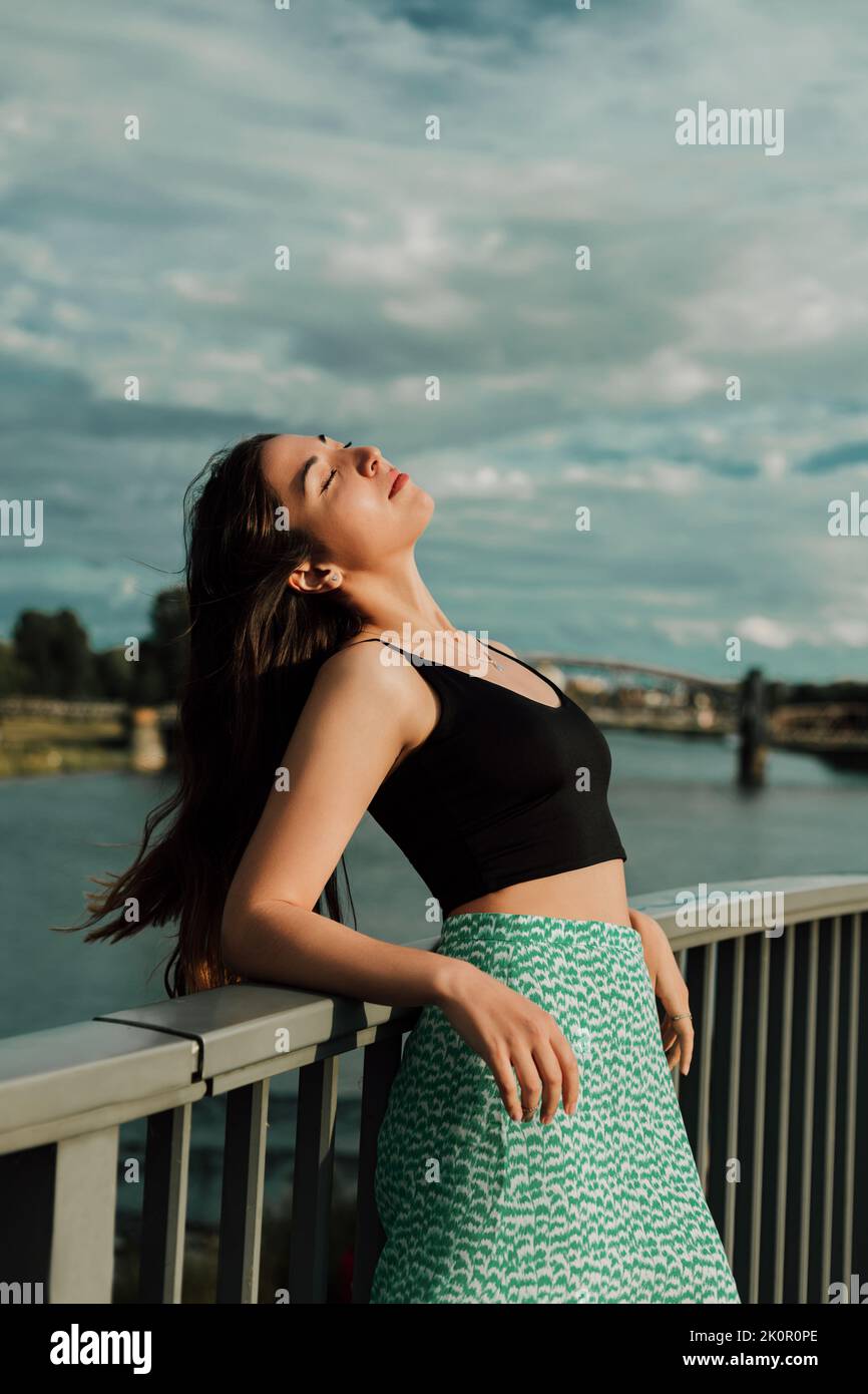 Portrait d'une belle jeune brune sur le pont au bord de la rivière Banque D'Images