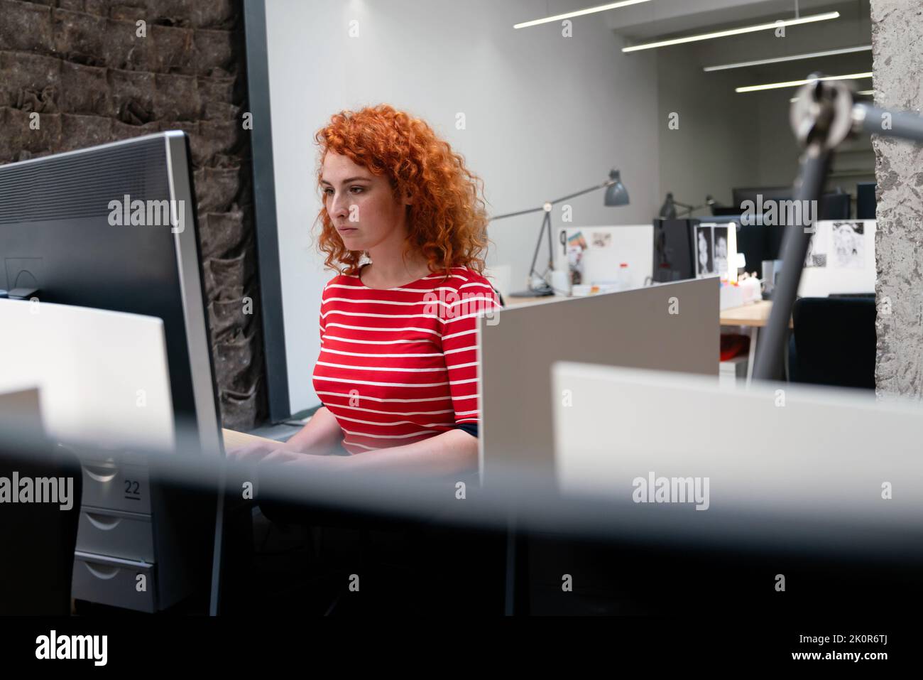 Jeune femme d'affaires concentrée travailleur analysant des données statistiques de ventes en ligne sur ordinateur Banque D'Images