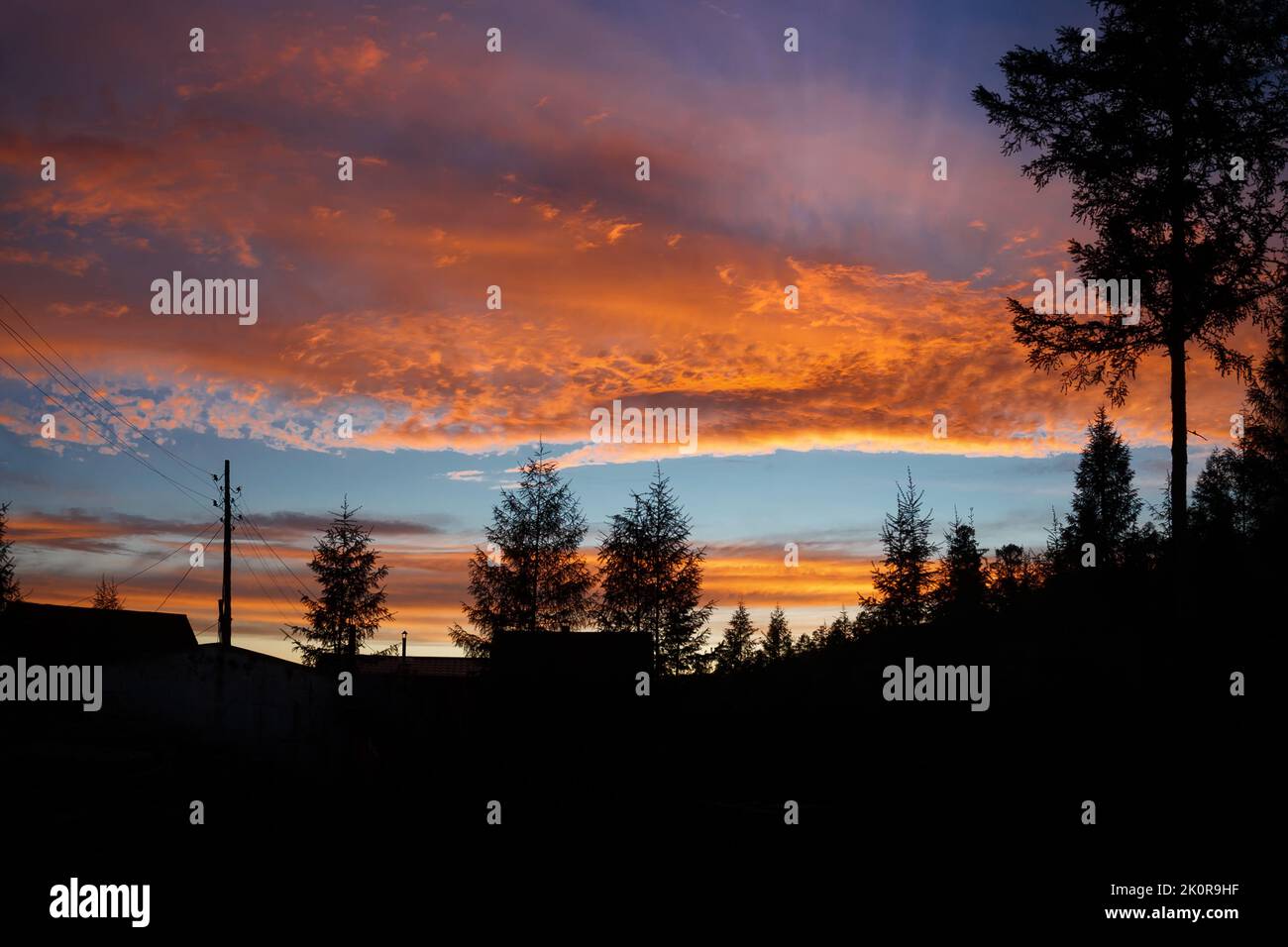 Paysage de village en soirée au coucher du soleil avec un ciel spectaculaire. Banque D'Images