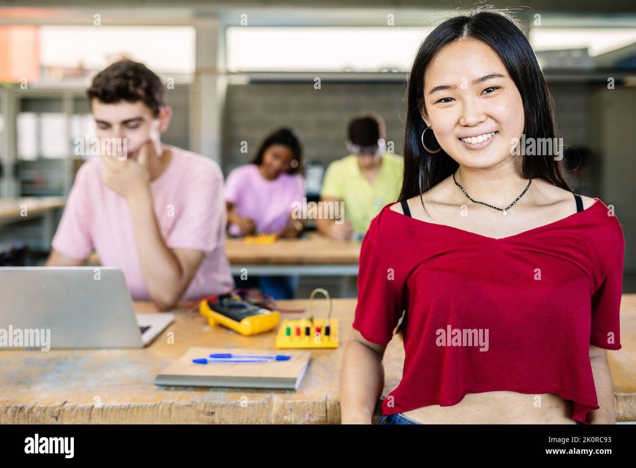 Portrait d'une jeune étudiante asiatique souriant devant un appareil photo debout en classe Banque D'Images