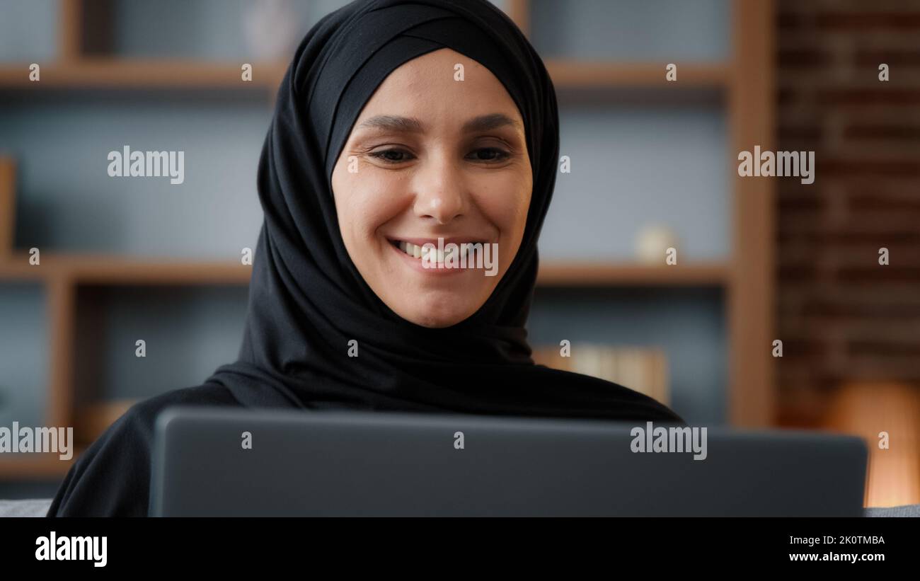Gros plan musulmane arabe femme islamique dans hijab regardant l'écran d'ordinateur portable moniteur e-commerce achat en ligne dans le service Internet magasin dactylographie Banque D'Images