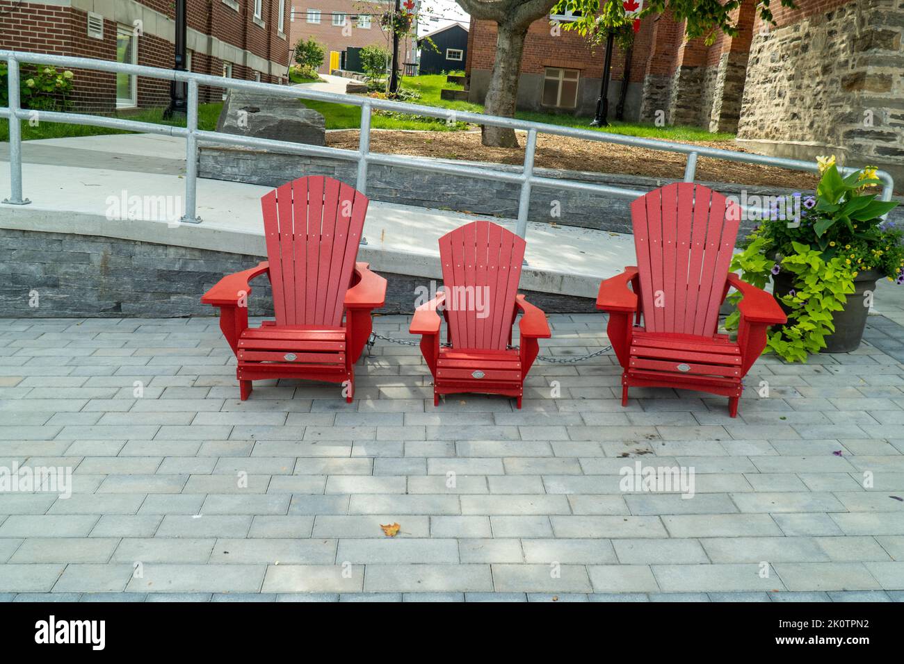 3 chaises rouges Muskoka sur la rue à Cottage Country, Ontario Banque D'Images