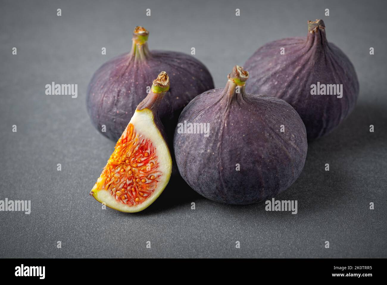 Figues fraîches sur fond gris. Beau bleu violet fruits gros plan Banque D'Images