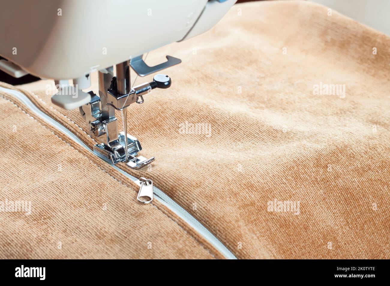 coudre une fermeture éclair blanche sur une machine à coudre. processus de couture Banque D'Images