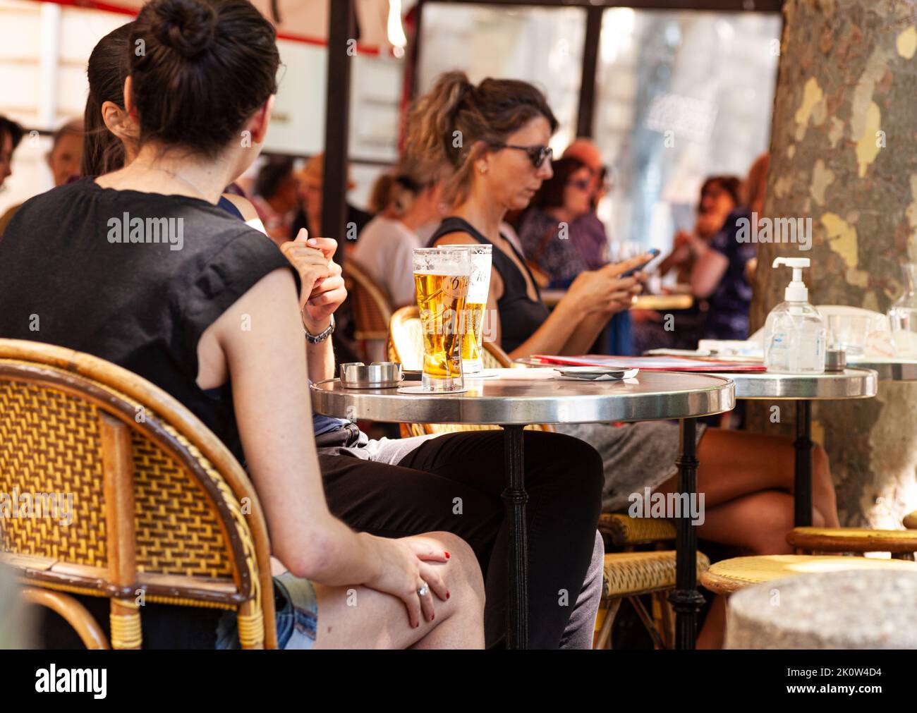 Paris, France - juillet 15 : groupe de jeunes assis à une table dans un bar d'été qui rient et boivent de la bière sur 15 juillet 2022 Banque D'Images