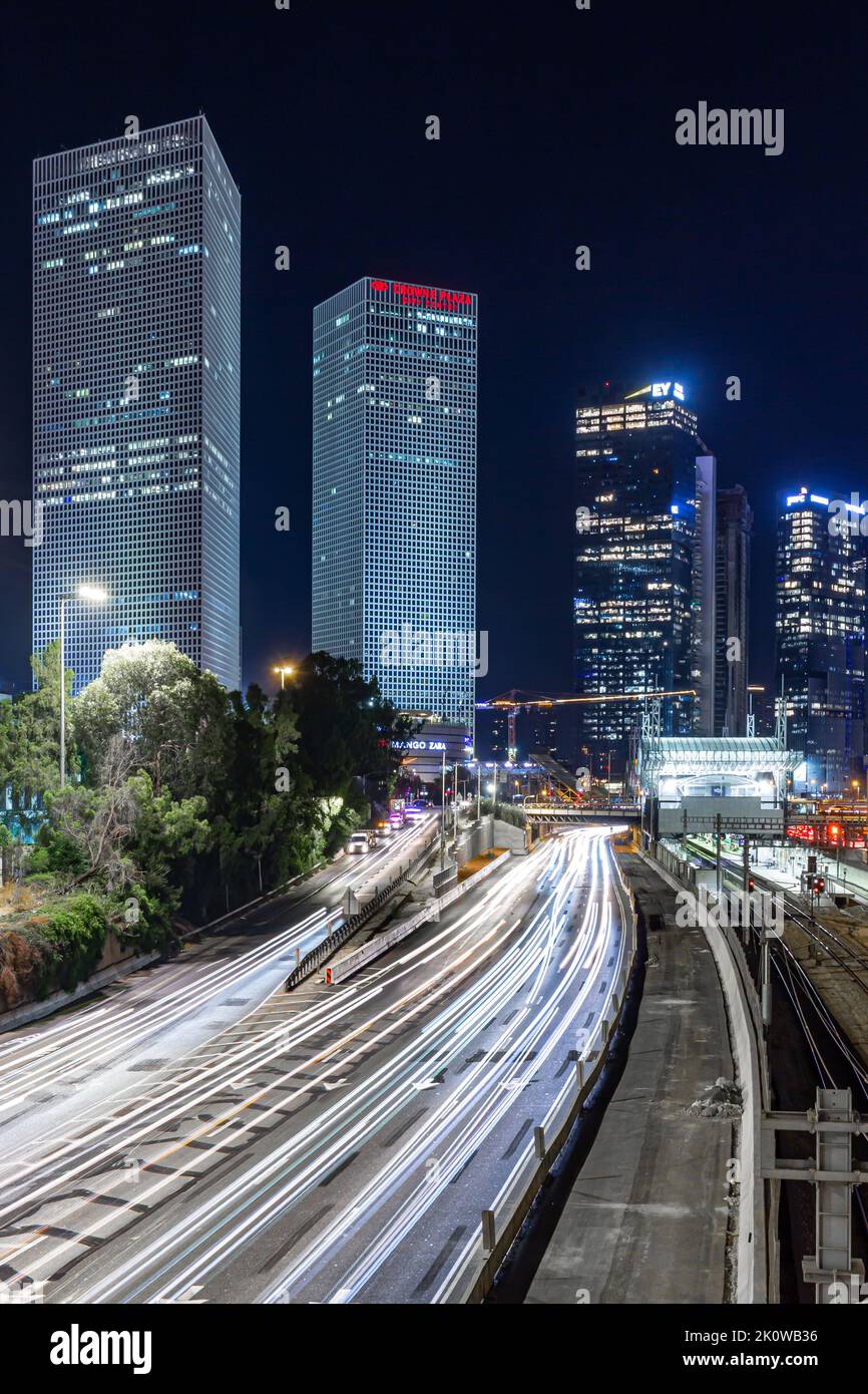 longue exposition de voitures dans la ville avec des bâtiments en arrière-plan la nuit. autoroute très fréquentée sous les immeubles de bureaux. Banque D'Images