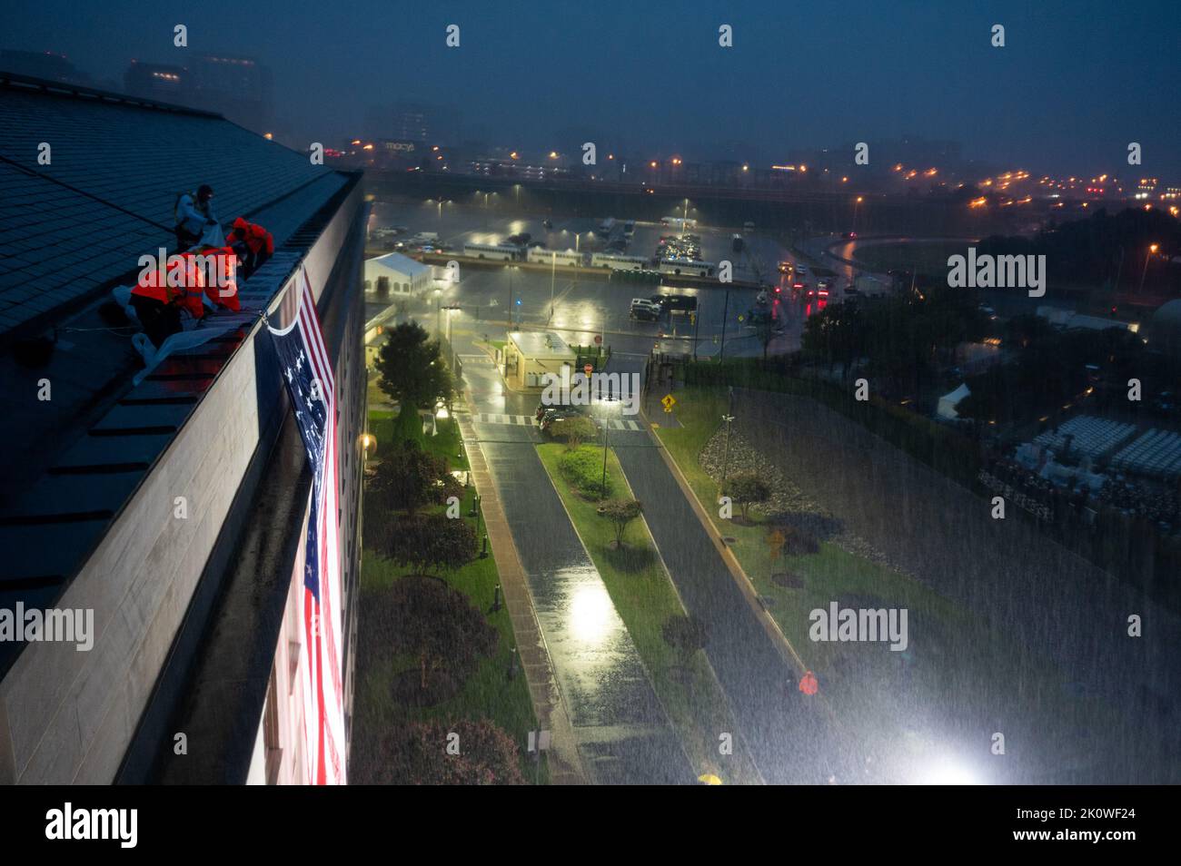 Washington, États-Unis d'Amérique. 11 septembre 2022. Les travailleurs du Pentagone dévoilent un drapeau américain à l'endroit où des terroristes ont fait entrer le vol américain 77 dans le bâtiment lors d'une cérémonie à l'aube en face du Mémorial national du Pentagone du 9/11, à 11 septembre 2022, à Arlington, en Virginie. La nation a marqué le 21st anniversaire des attaques terroristes d'Al-Qaida qui ont tué près de 3 000 personnes. Crédit : TSgt. Jack Sanders/DOD photo/Alamy Live News Banque D'Images