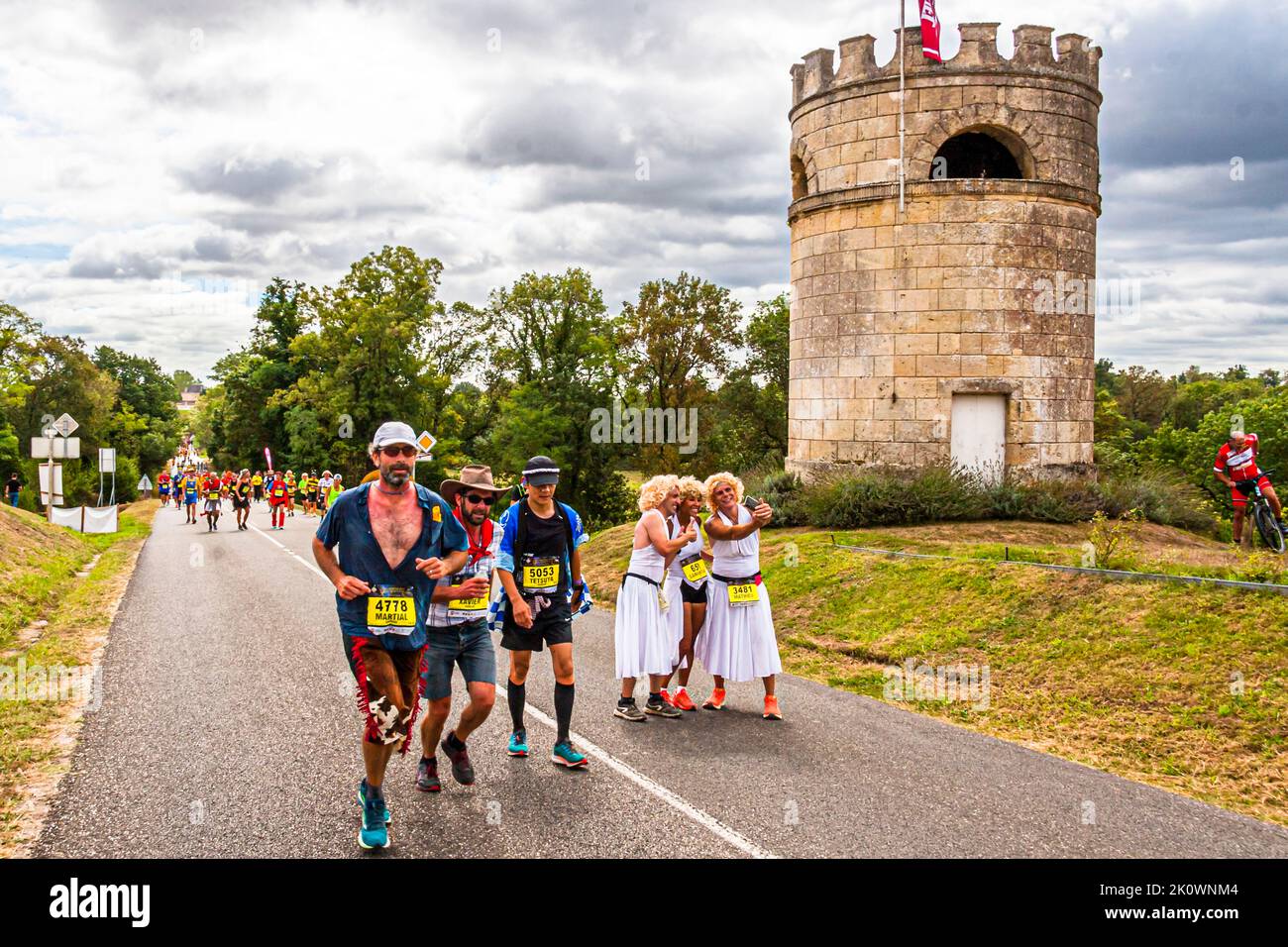 Le peloton du Marathon des Châteaux du Médoc 36th est magnifiquement costumé et interprète le thème de la « vie » d'une manière hautuère et folle. Ici, Marilyn Monroe pose trois fois, tandis que deux cow-boys osent monter la longue montée jusqu'au prochain château. Lesparre-Médoc, France Banque D'Images