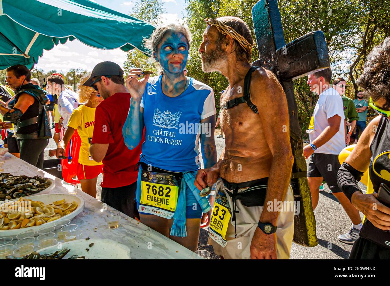 Peu avant la fin du Marathon des Châteaux du Médoc 36th, les coureurs rechargent leurs batteries avec des huîtres et du vin blanc. Même Jésus ne semble pas être contre les plaisirs terrestres. Lesparre-Médoc, France Banque D'Images