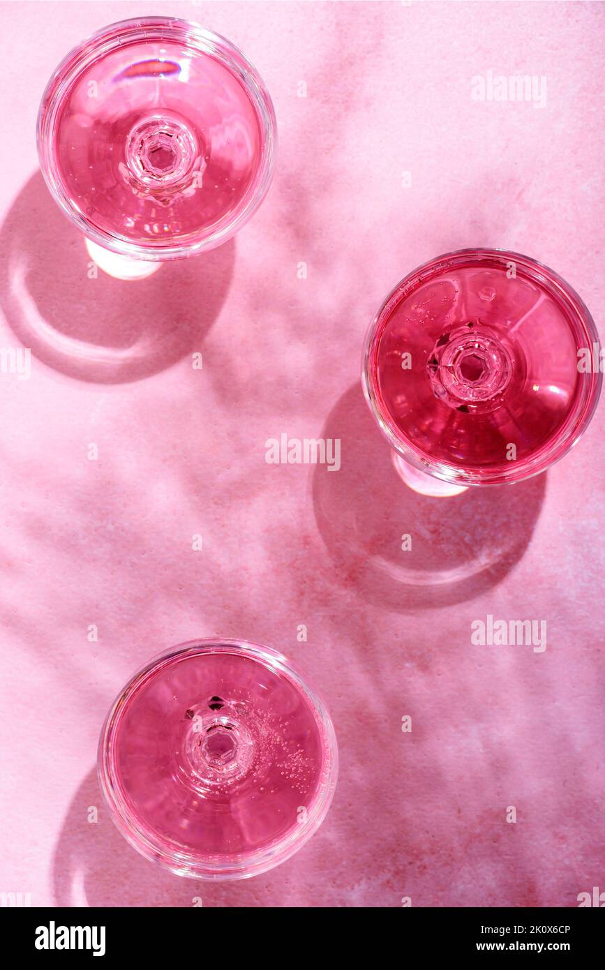 Champagne rose dans des verres sur une table en marbre rose avec ombre à la paume. Cocktail d'été sur la plage avec vin de rose boisson alcoolisée sur fond texturé W Banque D'Images
