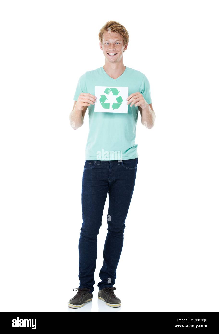Nous pouvons tous faire notre part. Un jeune homme heureux à tête rouge tenant un panneau de recyclage - portrait. Banque D'Images