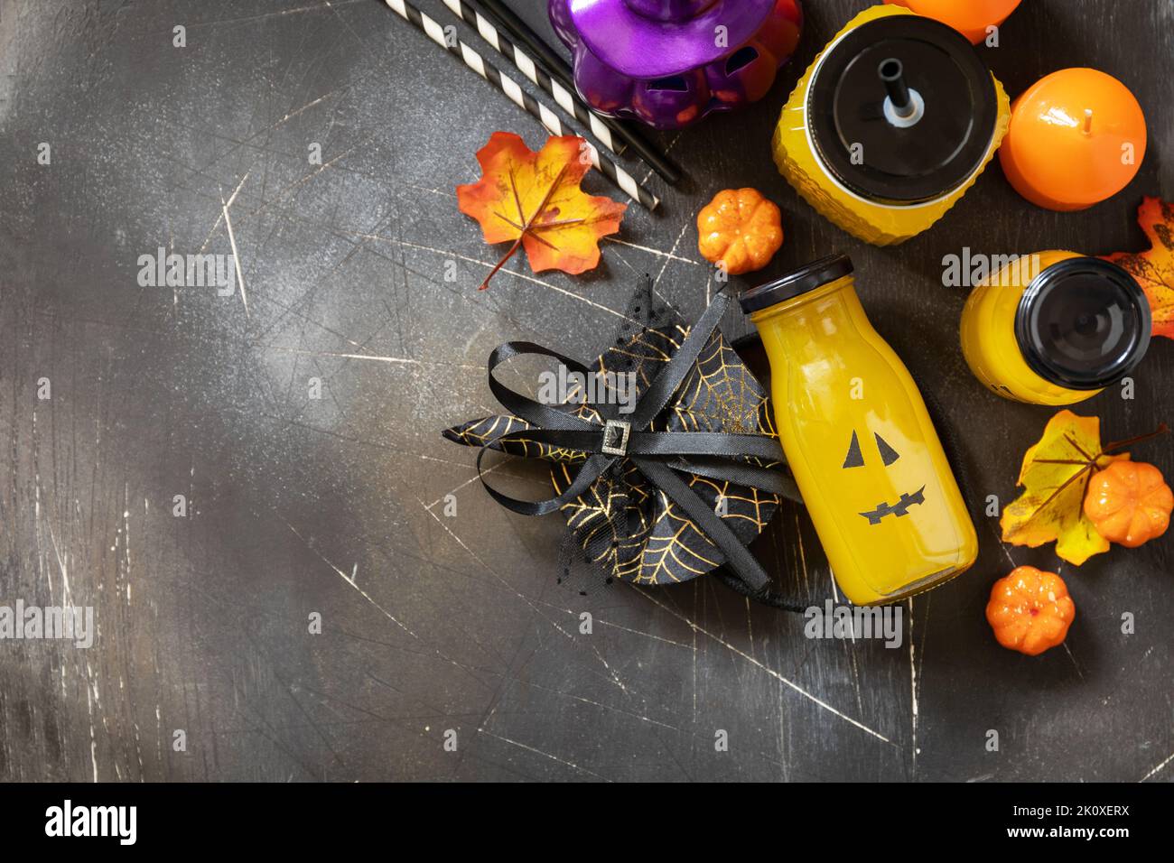 Queues de macktails d'Halloween. Cocktails de citrouille et limonade en pots de verre décorés de visages effrayants et de décorations sur fond de pierre sombre. Vue de dessus Banque D'Images