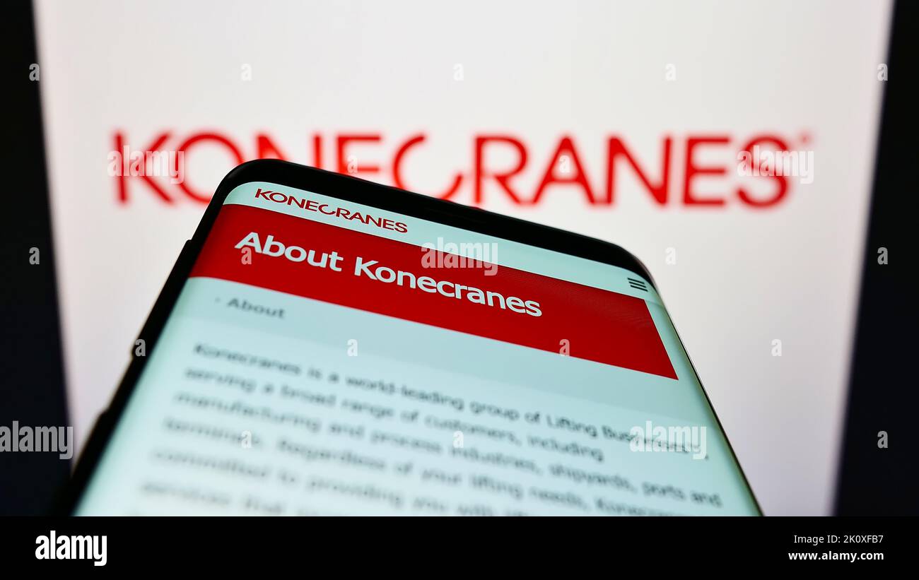 Téléphone mobile avec le site web de la société finlandaise de grue Konecranes Oyj sur l'écran devant le logo de l'entreprise. Faites la mise au point dans le coin supérieur gauche de l'écran du téléphone. Banque D'Images