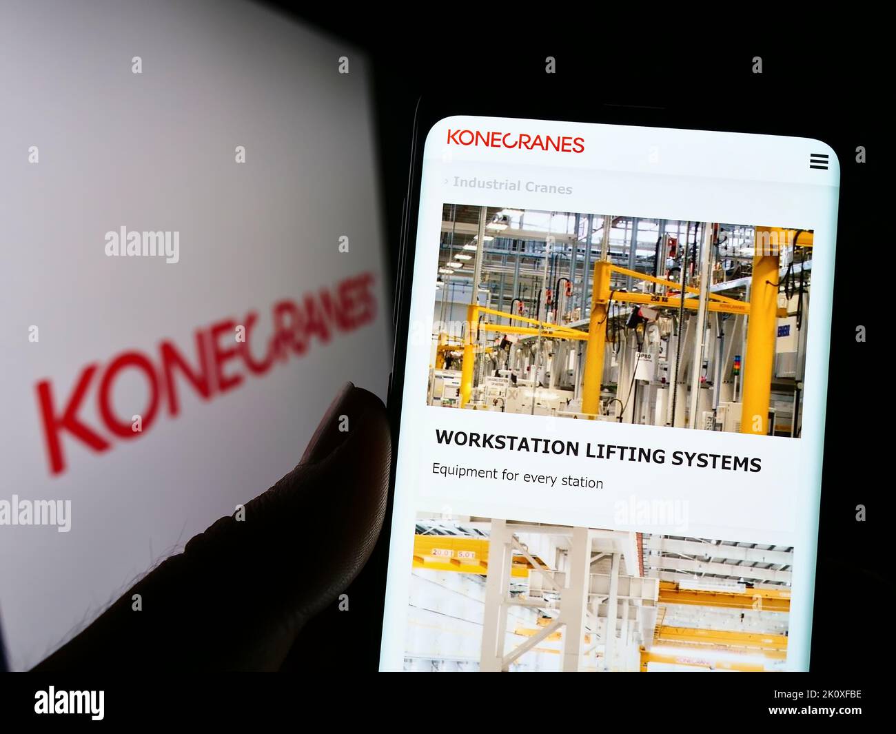 Personne tenant un smartphone avec la page Web de la société finlandaise de grue Konecranes Oyj à l'écran devant le logo. Concentrez-vous sur le centre de l'écran du téléphone. Banque D'Images