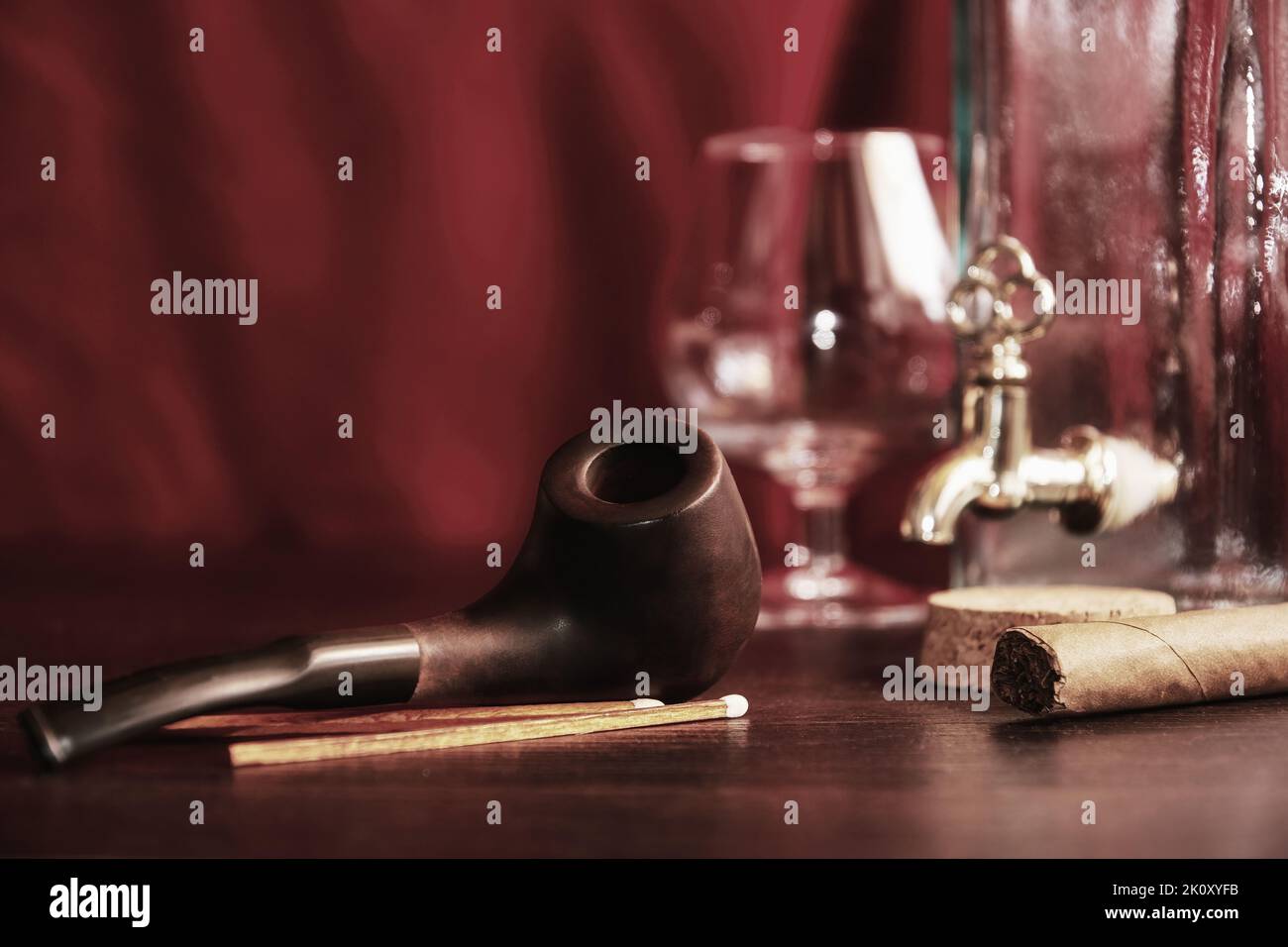 Moody man's table dans l'armoire avec cognac, pipe fumeur, allumettes, bouteille. Activités de loisirs et concept de détente en soirée Banque D'Images