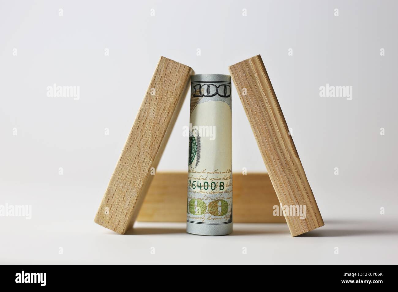 Billet de 100 dollars recouvert de cubes de bois sur fond clair. Concept de devise Banque D'Images