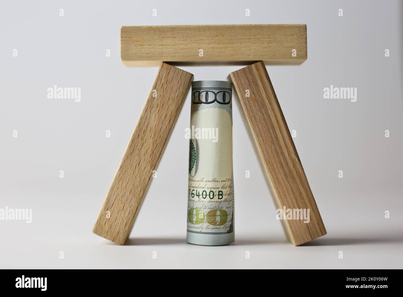 Billet de 100 dollars recouvert de cubes de bois sur fond clair. Concept de devise Banque D'Images