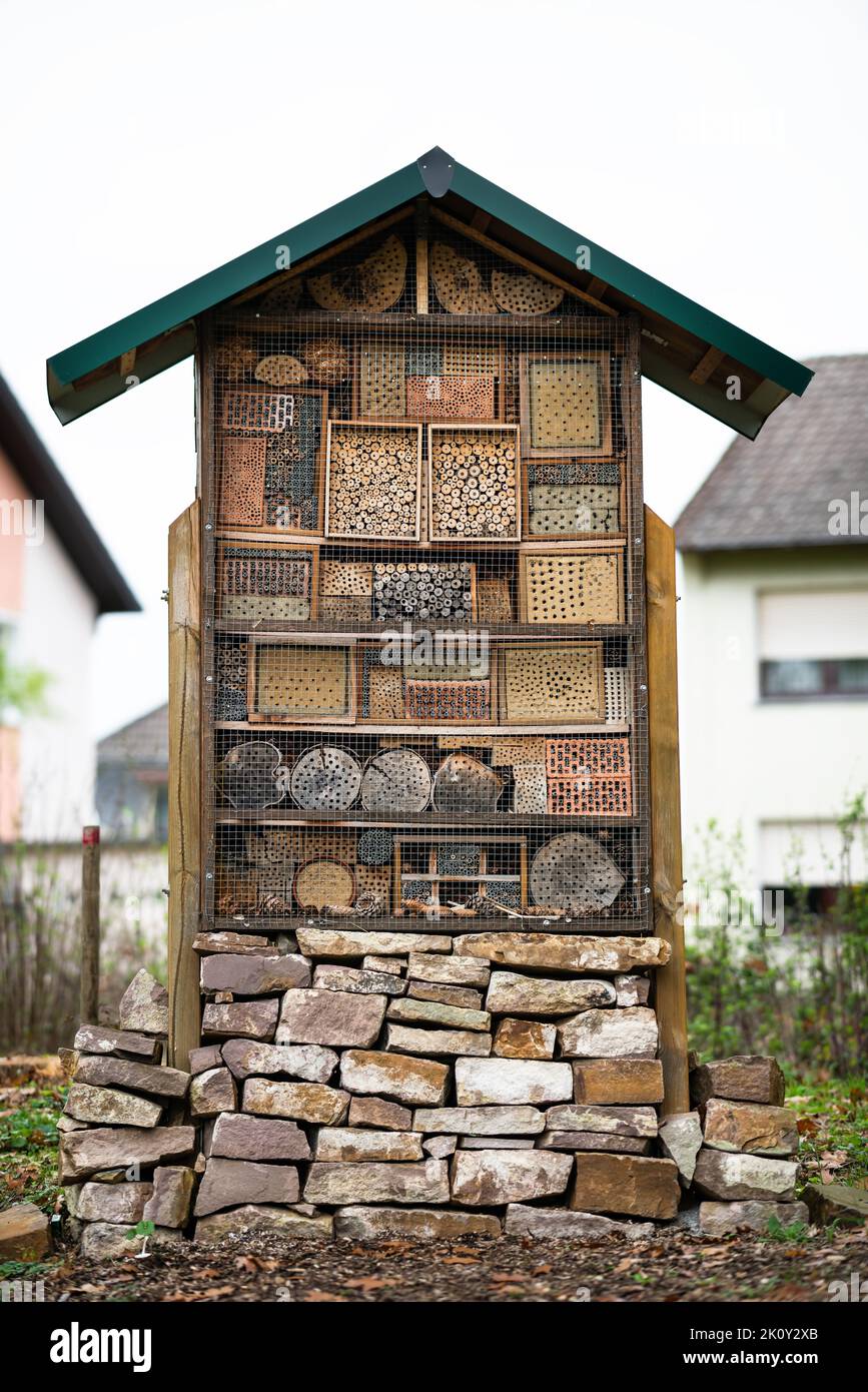 Grand et bel hôtel d'insectes en bois et en pierre créé pour fournir un abri pour les insectes comme les abeilles pour empêcher l'extinction dans la zone résidentielle. Banque D'Images
