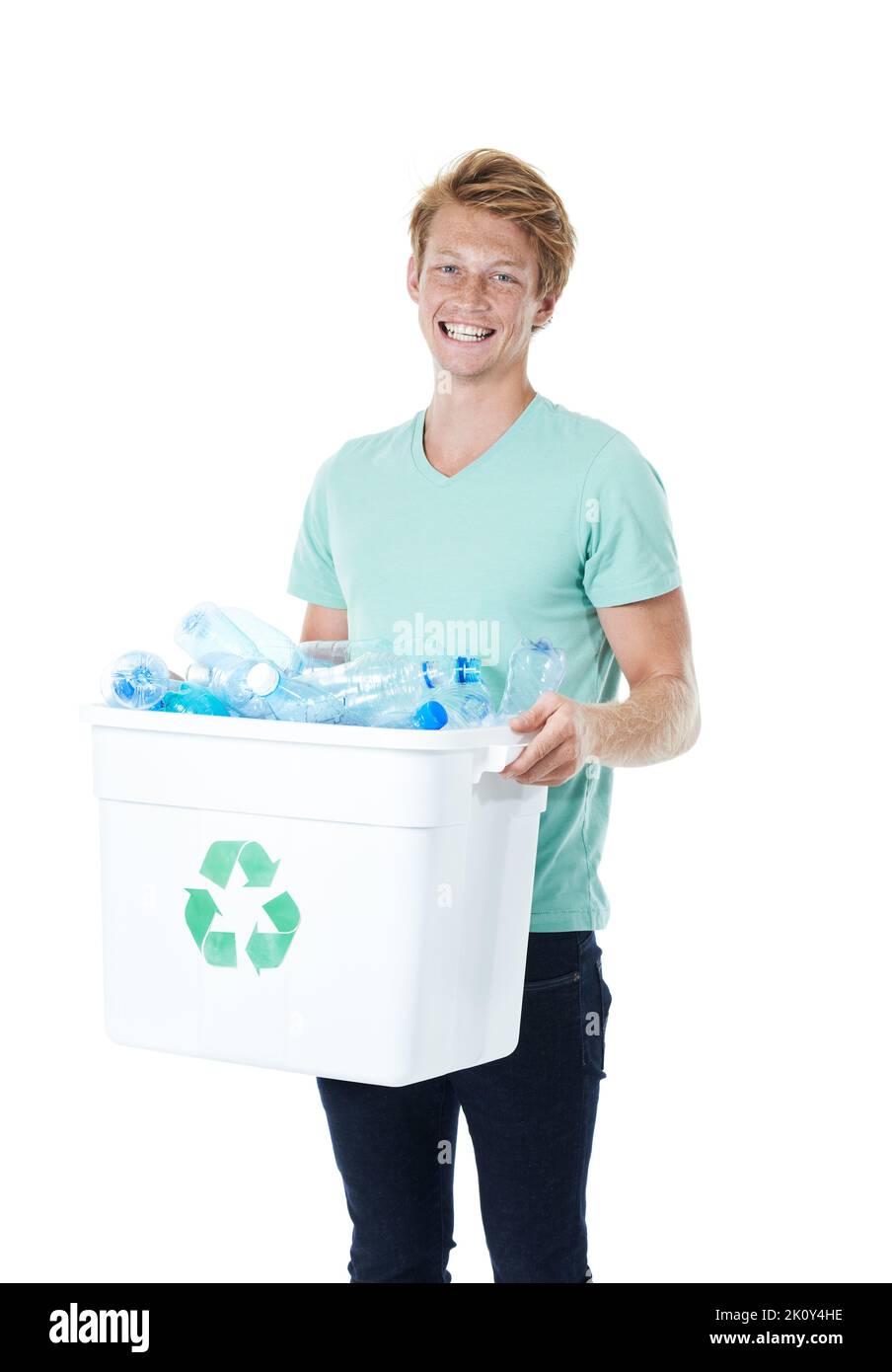 Prenez le temps de recycler. Un jeune homme heureux à tête rouge tenant un bac de recyclage rempli de bouteilles en plastique vides. Banque D'Images