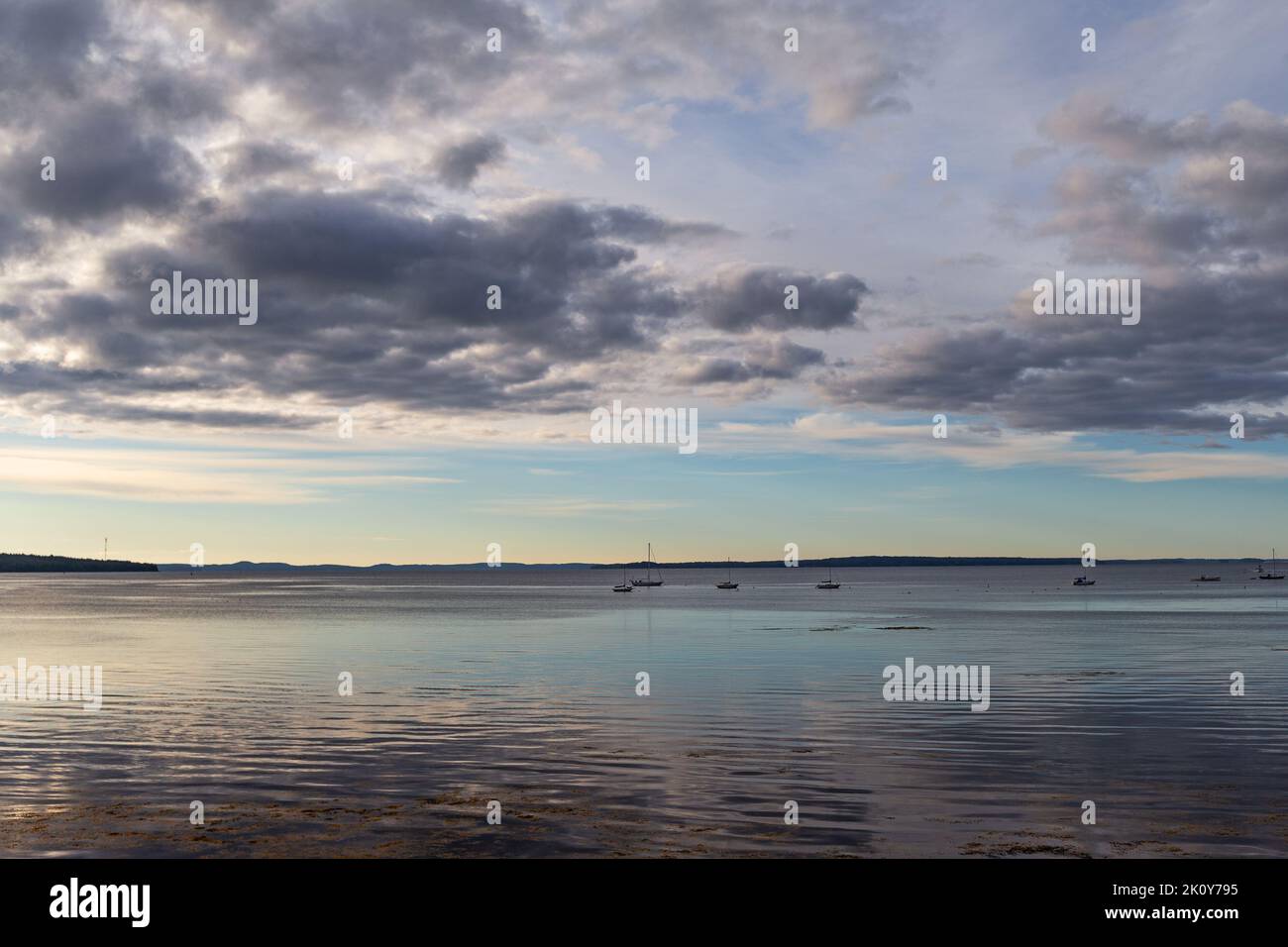 Vue sur Penobscot Bay dans le Maine avec des bateaux amarrés au loin dans la lumière du matin. Banque D'Images