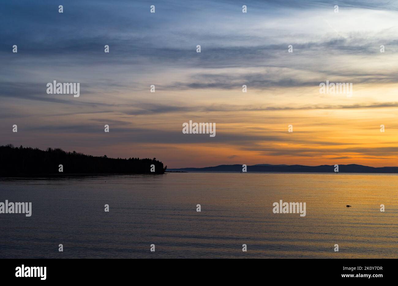 Lever du soleil sur la côte du Maine avec une bouée de homard flottante et la péninsule de Sears Island en arrière-plan. Banque D'Images