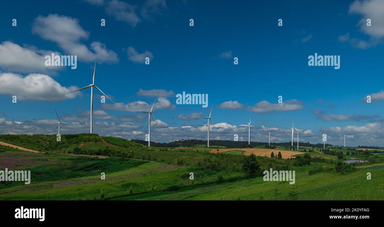 Paysage de campagne de collines et de champs de turbines avec fond bleu ciel nuage. Windmill Power Farm. Banque D'Images