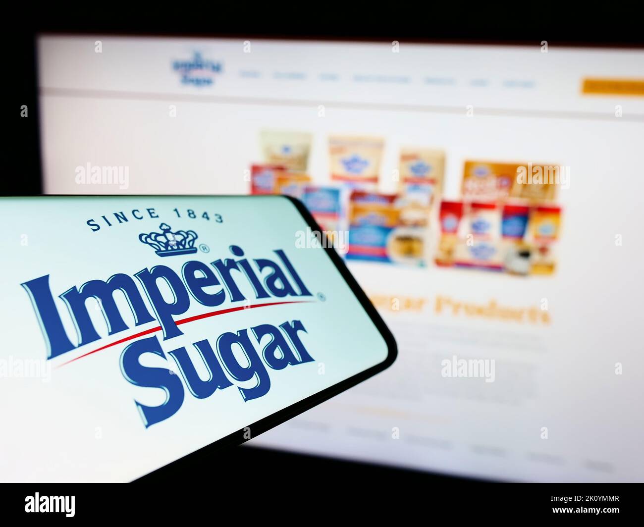 Téléphone mobile avec logo du producteur américain de sucre Imperial Sugar Company à l'écran devant le site Web d'affaires. Concentrez-vous sur le centre de l'écran du téléphone. Banque D'Images