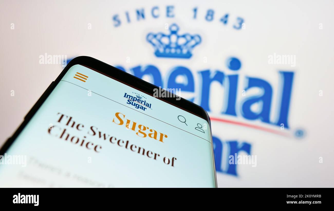 Smartphone avec le site Web du producteur américain de sucre Imperial Sugar Company à l'écran devant le logo de l'entreprise. Faites la mise au point dans le coin supérieur gauche de l'écran du téléphone. Banque D'Images